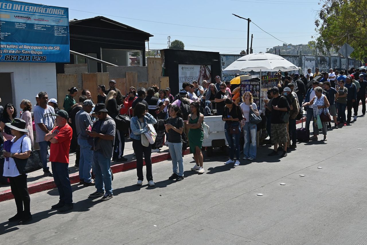 Pedestrians wait in line at the San Ysidro Port of Entry border crossing in Tijuana, Mexico, on Friday, July 19. The US Customs and Border Protection agency said it’s experiencing processing delays due to the global technology outage.