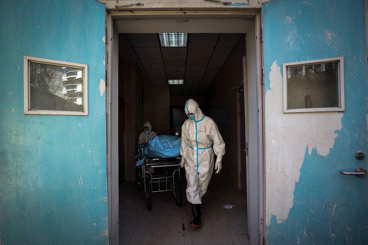 Medical workers move a person who died from the novel coronavirus at a hospital in Wuhan in central China's Hubei province on Sunday, February 16.