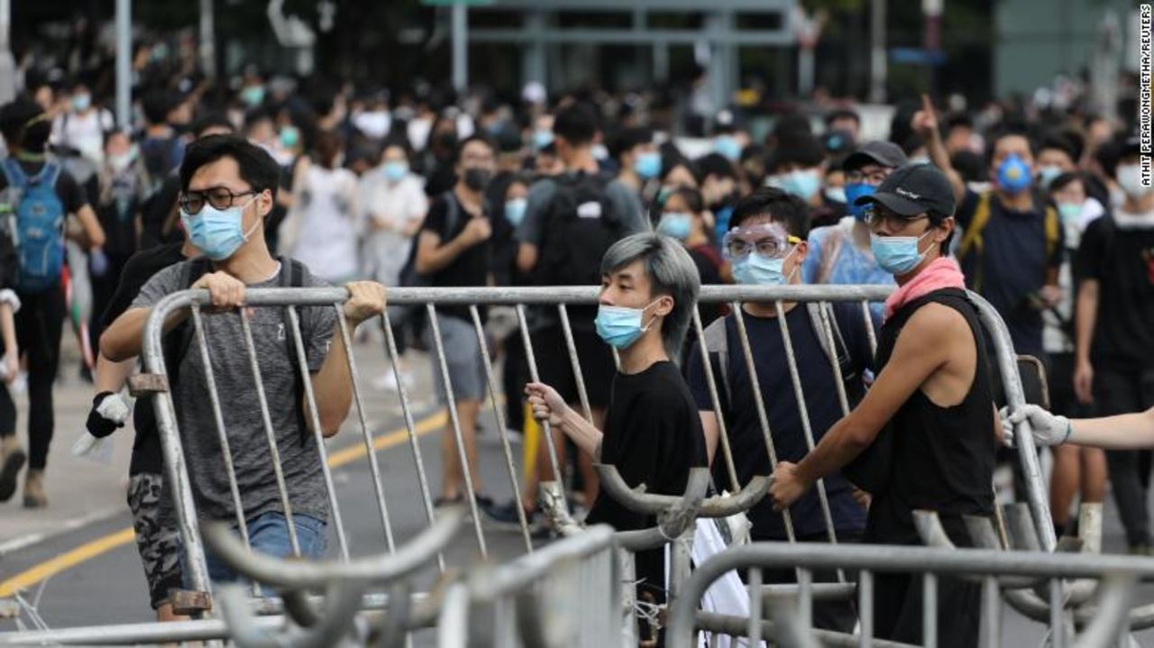 Demonstrators remove metal barricades in Hong Kong.