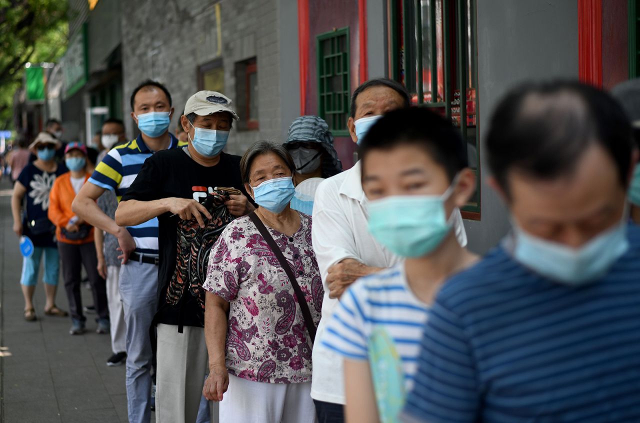 People wearing face masks queue to take a swab test during mass testing for the Covid-19 in Beijing on June 21.
