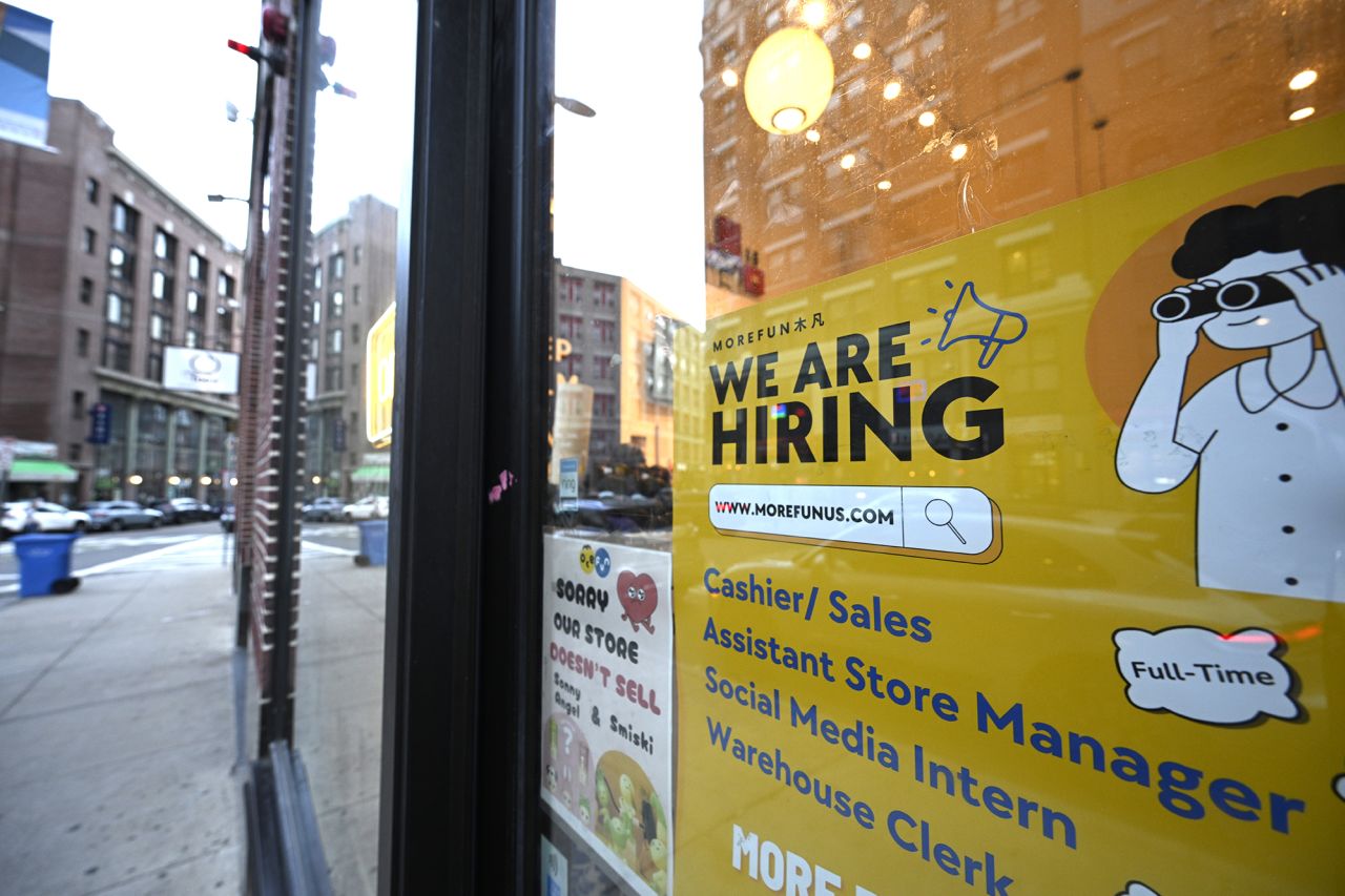 A "We Are Hiring" sign advertising job openings is viewed outside of a store in the Chinatown neighborhood of Boston on July 10.