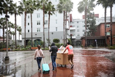 In this March 18 file photo, students and their parents move their belongings from their dormitories at San Diego State University.