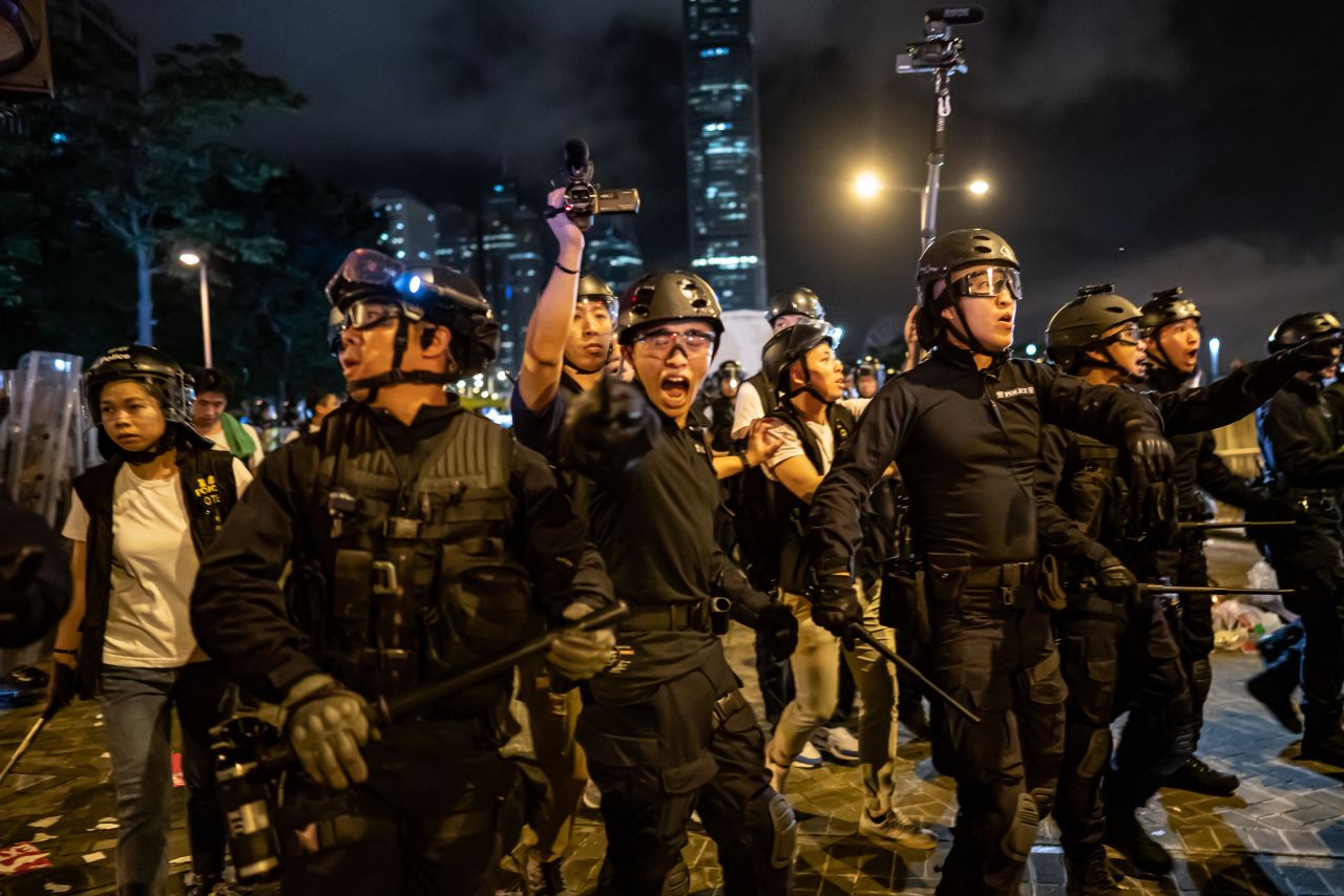 Police officers charge toward protesters after a rally against the proposed extradition law at the Central Government Complex.