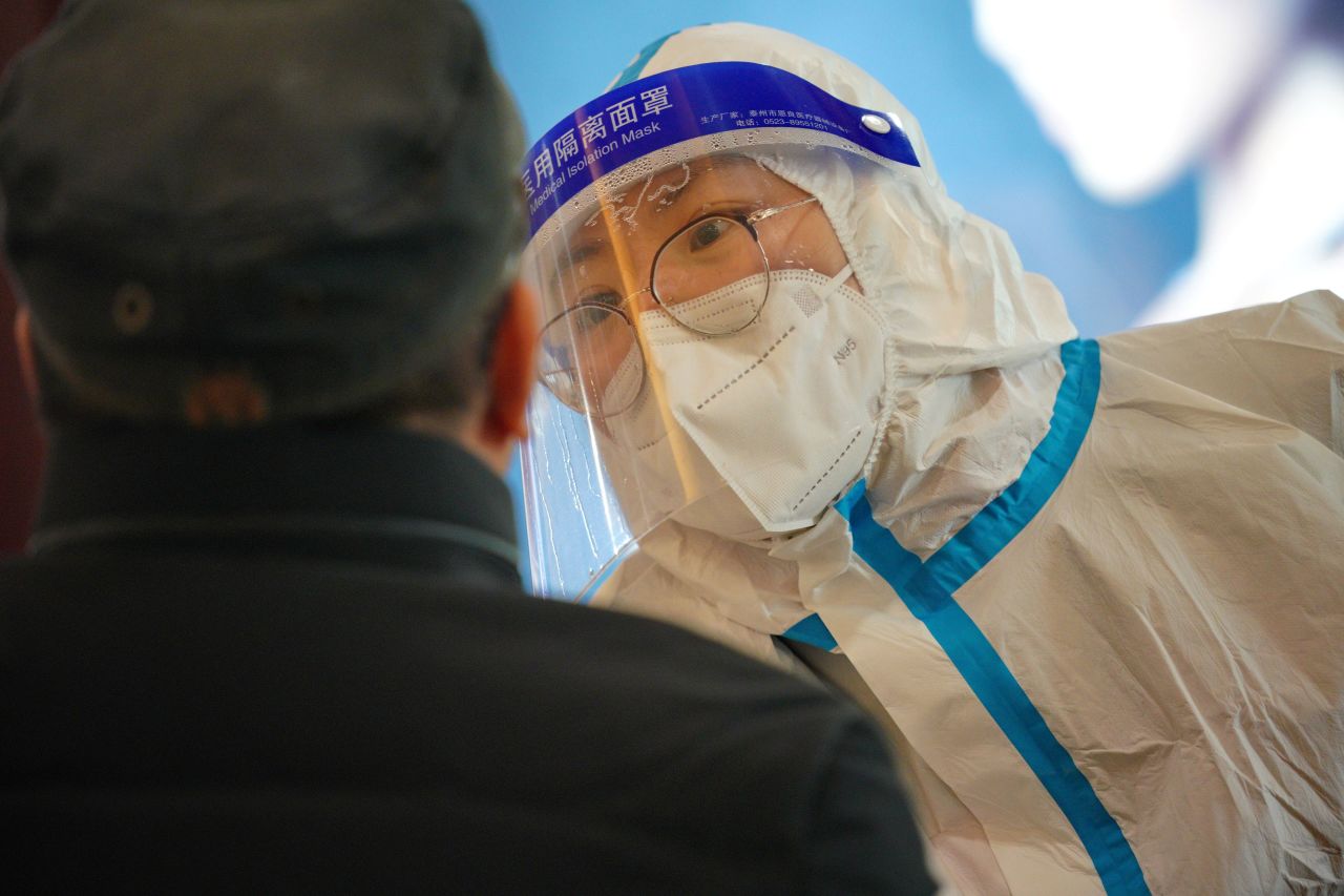 A medical worker collects a swab sample from a person at a Covid-19 testing site in the Qiaoxi District of Shijiazhuang, China, on January 20.