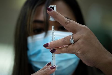 A pharmacist dilutes the Covid-19 vaccine while preparing it to administer to staff and residents at a senior living community in Falls Church, Virginia, on December 30.