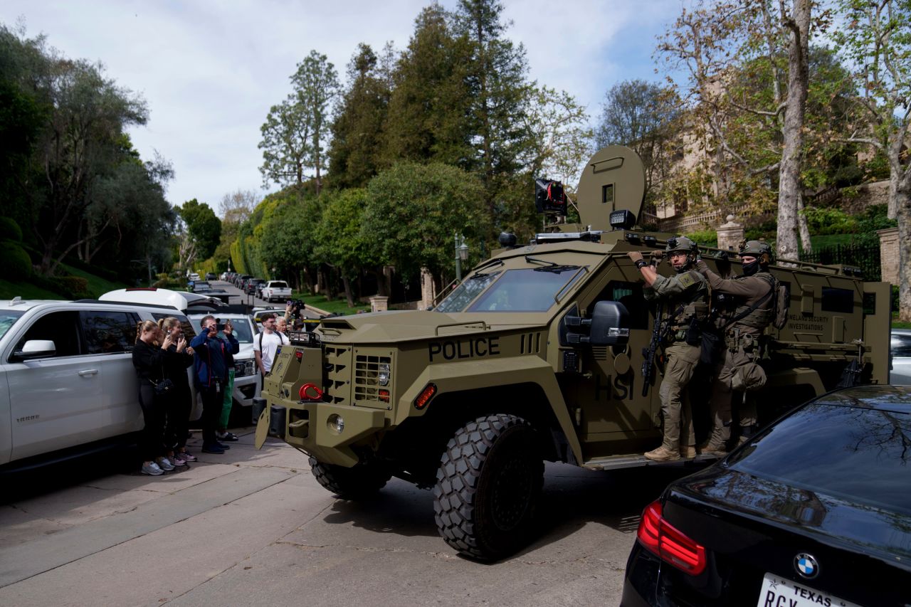 Police drive a vehicle near a property owned by Sean 