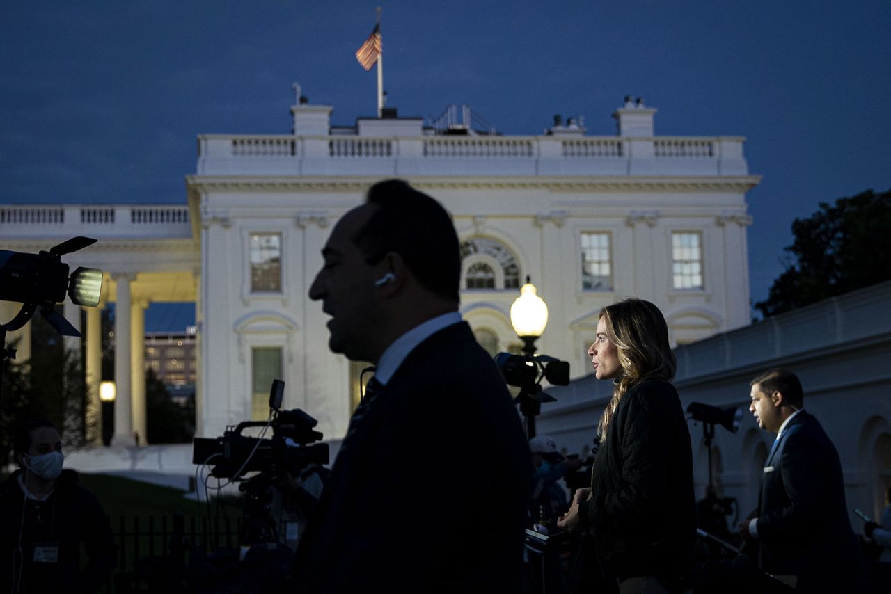 Members of the media report outside of the White House in Washington on Tuesday. 