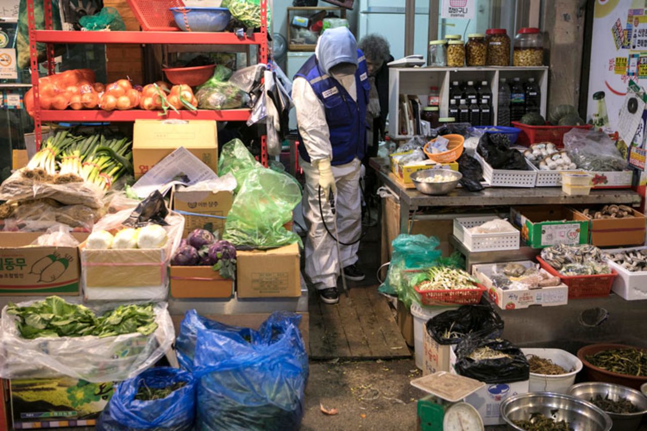 A disinfection worker in protective gear sterilizes groceries against the novel coronavirus in Seoul, on Friday, February 7.