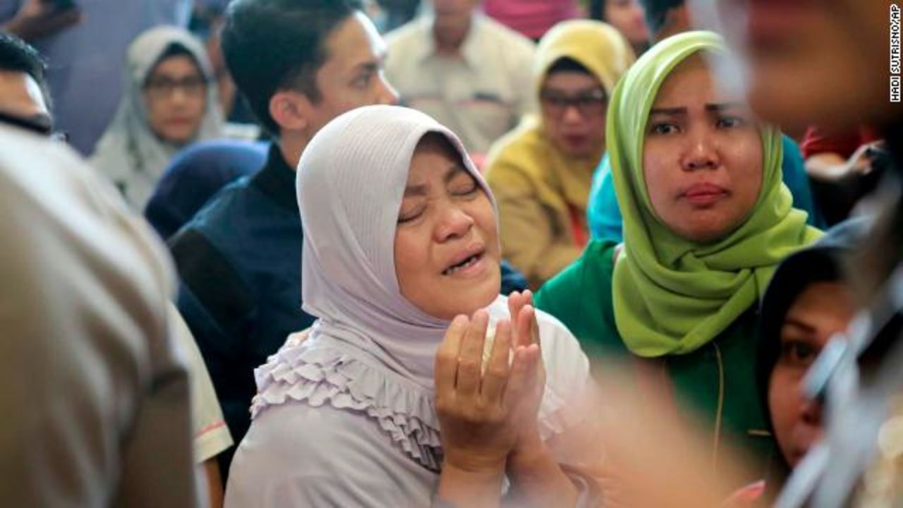 A relative prays at the Pangkal Pinang airport in Indonesia on Monday as she waits for news from officials. 