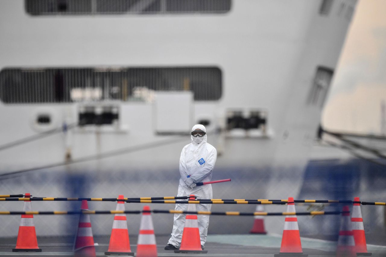 An official in protective gear stands near the Diamond Princess cruise ship, quarantined at Yokohama Port in Yokohama, Japan, on Thursday, February 20.