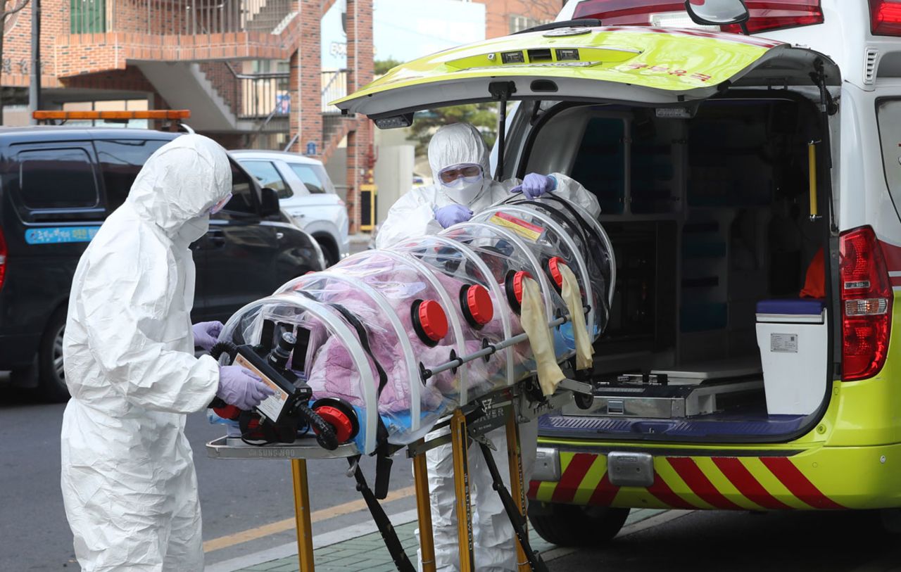 Medical workers hoist a patient infected with the coronavirus onto an ambulance in Ulsan, South Korea on Monday, December 7.