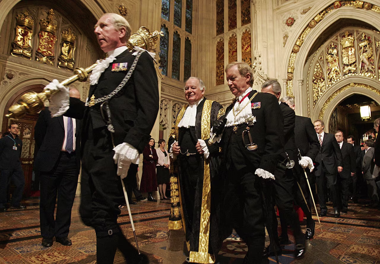 Black Rod (center, right) carrying his black rod.
