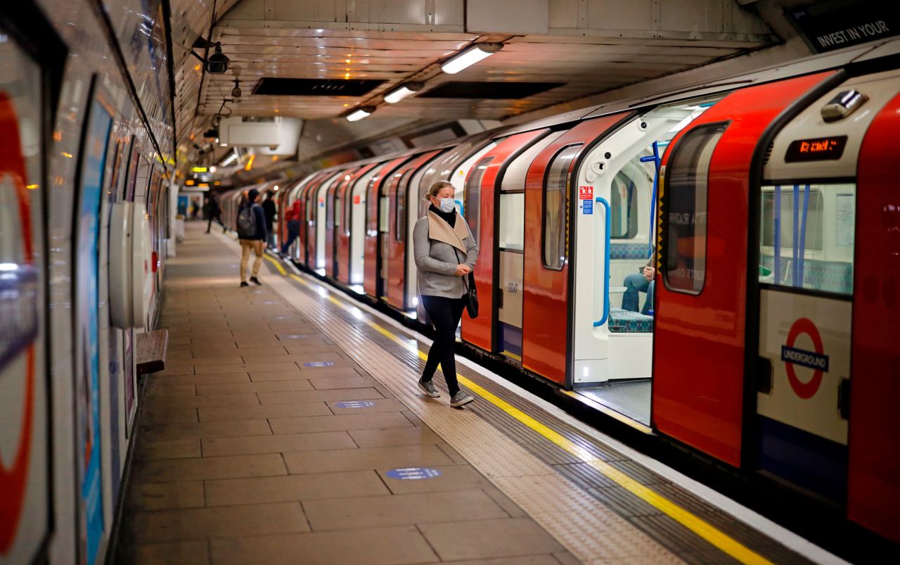 A woman wearing walks alongside a London Underground Tube train on May 11.