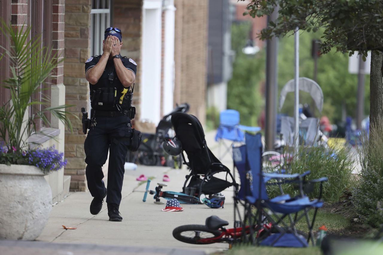 A Lake County, Illinois, police officer walks down Central Avenue in Highland Park on July 4, after a shooter fired on the Fourth of July parade. 