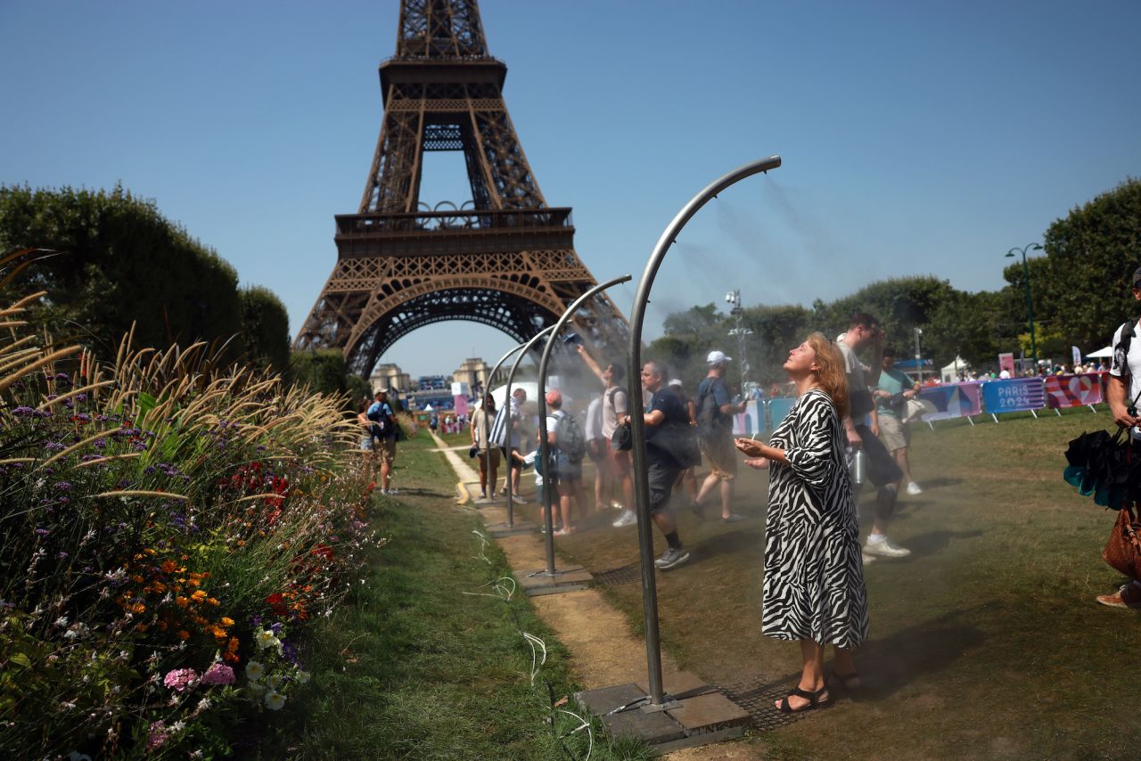  Spectators cool off under water misters in front of the Eiffel Tower on Wednesday.