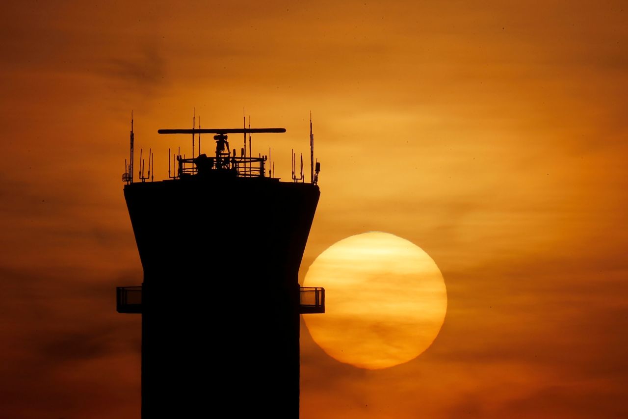 The sun sets behind the air traffic control tower at Chicago Midway International Airport on Tuesday, March 17.