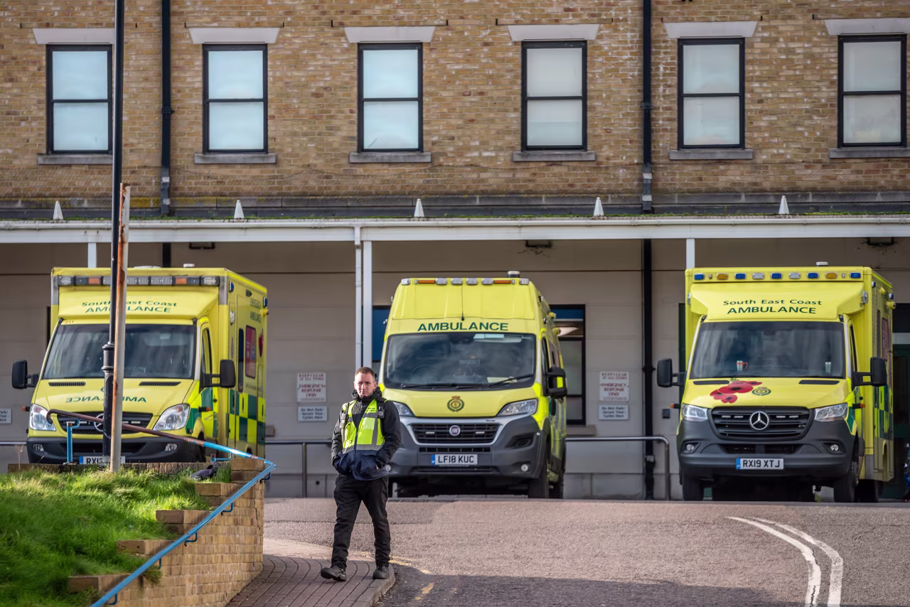A man walks past ambulances parked outside the Royal Sussex County Hospital where a third person has tested positive for coronavirus in the UK on February 6.