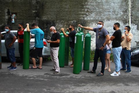Family members of patients hospitalized with Covid-19 line up with empty oxygen tanks in an attempt to refill them in Manaus, Brazil, on Friday, January 15.