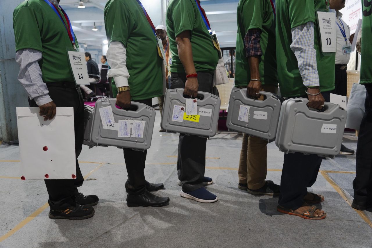 Election officials carry sealed electronic voting machines at a counting center in Mumbai on Tuesday.