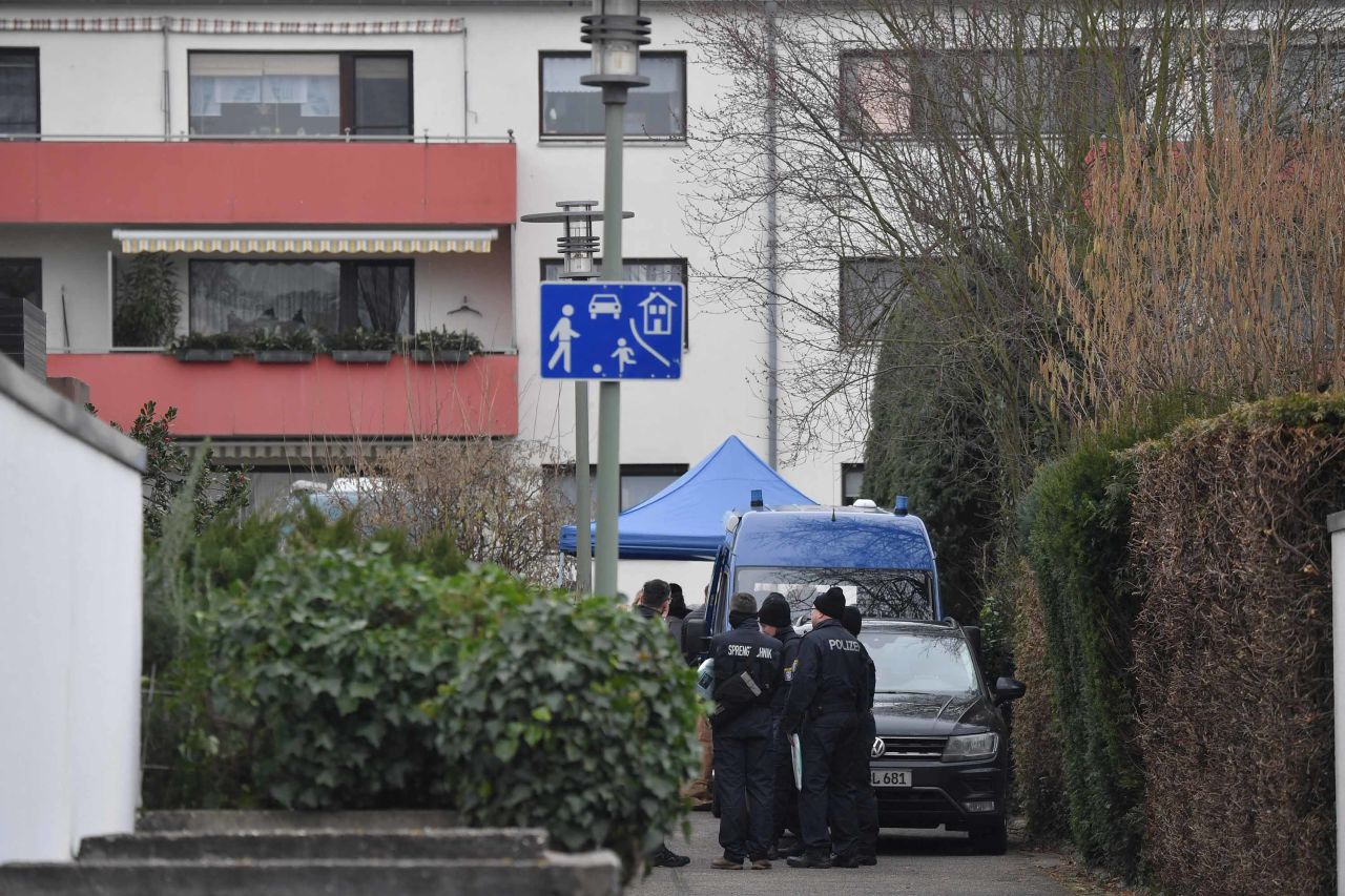 Police officers stand by the house where the suspect was found dead in Hanau, Germany.