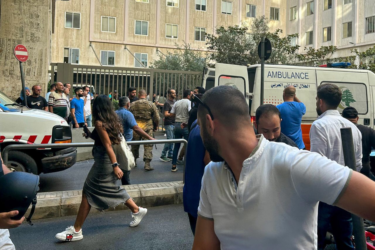 People react near an ambulance as the wounded are brought to a hospital in Beirut, Lebanon, on September 17, after thousands of people were wounded when Hezbollah members' paging devices exploded simultaneously across Lebanon. 