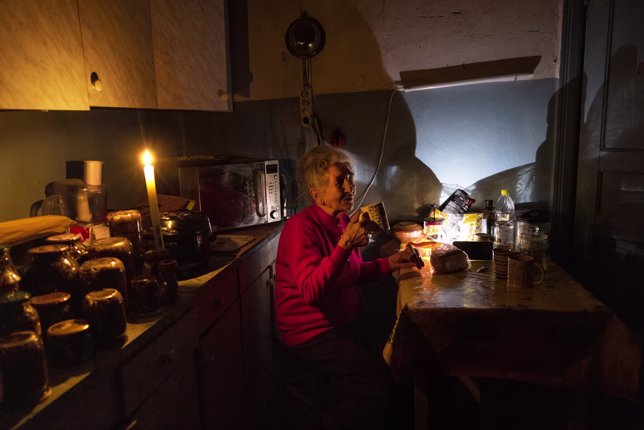 Natalia Zemko, 81, drinks tea in her apartment during a power outage in in Kyiv, Ukraine on October 22.