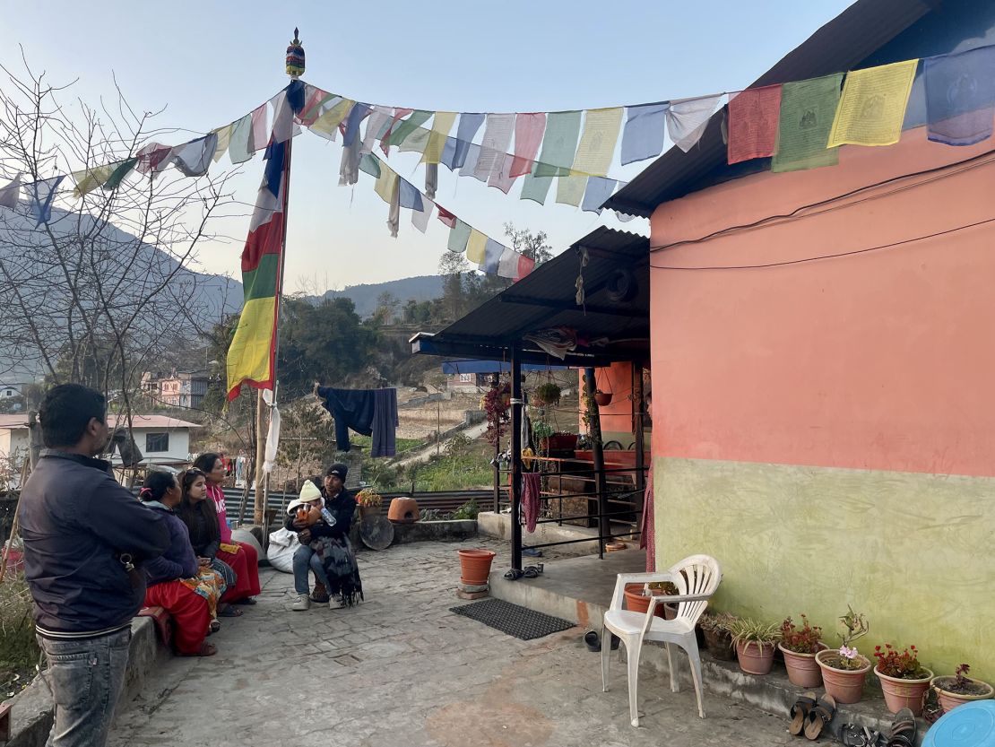 Relatives of Buddhi Maya Tamang, second from left, sit with her outside her house. Her husband, Shukra Tamang, signed up to fight with Russia's forces and is feared dead.