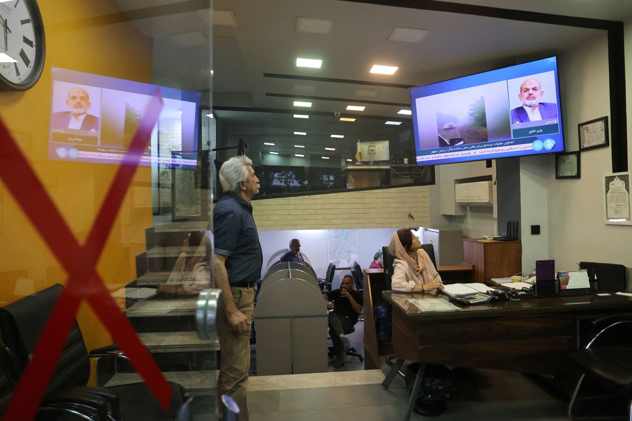 People follow the news about the crash of a helicopter carrying Iran's President Ebrahim Raisi, in a shop in Tehran, Iran, on May 19.