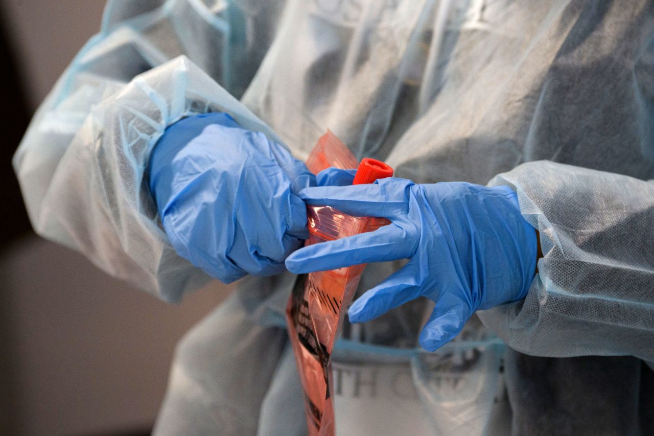 A health care worker at Los Angeles International Airport in California places a Covid-19 nasal swab test into a specimen bag on November 18.