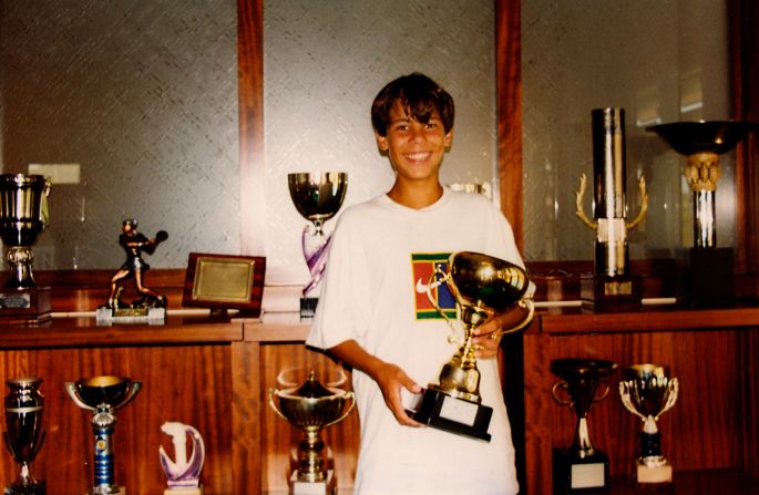 A young Nadal poses with his trophies at a tennis club in Mallorca, Spain. He was coached by his uncle Toni, who <a href="https://www.cnn.com/2017/02/15/tennis/toni-rafa-nadal/index.html">persuaded him to play left-handed</a> despite being naturally right-handed.