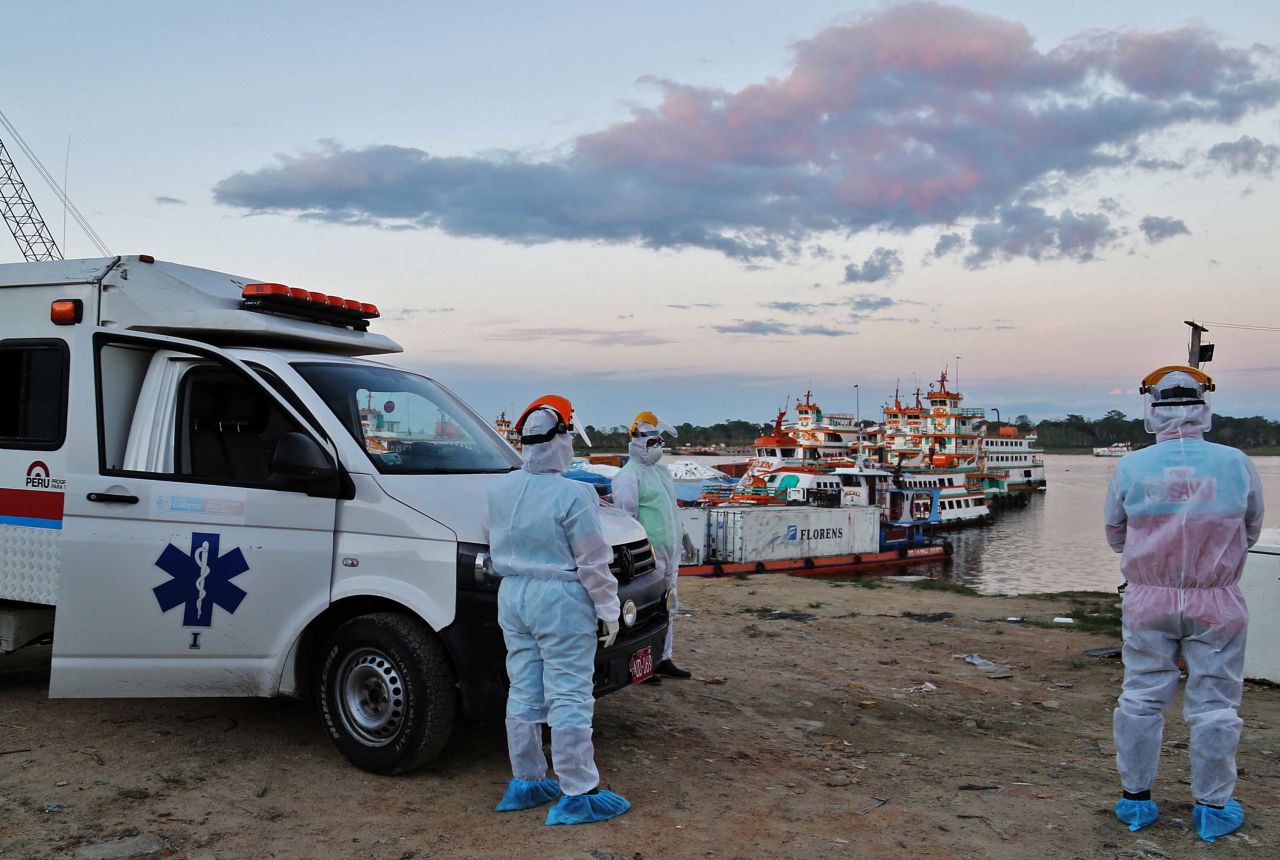 Medical staff wait at a port to transfer COVID-19 patients brought from nearby communities in Iquitos, Peru, on June 18.