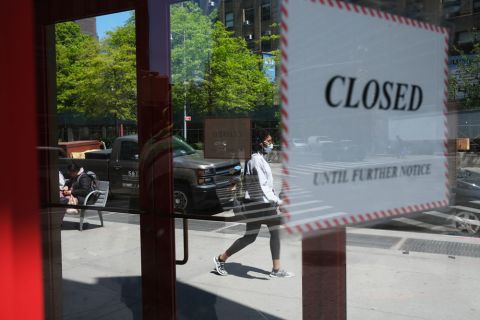 People walk through a shuttered business district in Brooklyn on May 12, in New York City. 