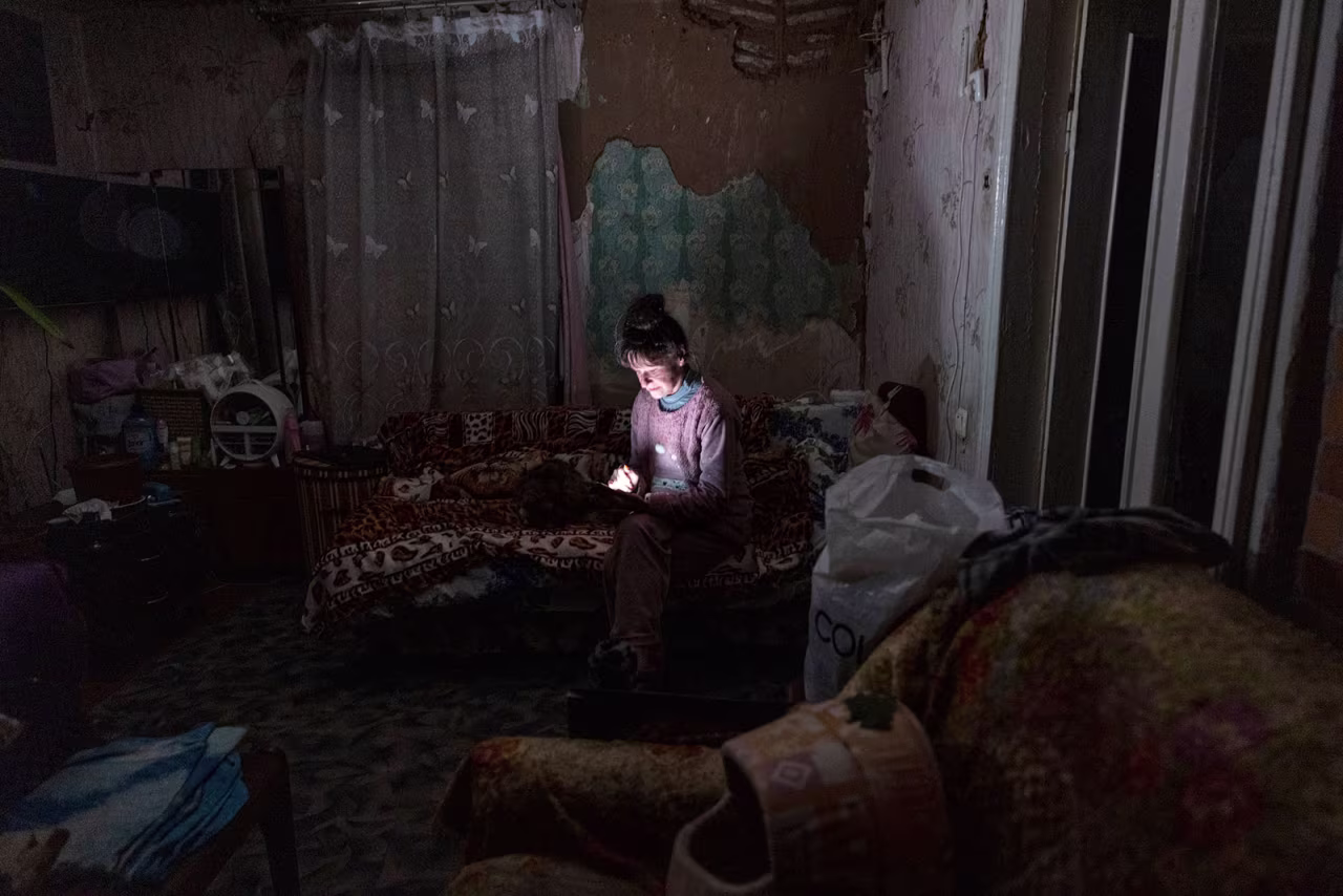 Tetyana Safonova looks at her mobile phone during a power outage on October 20, in Borodyanka, Ukraine.