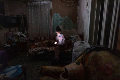 Tetyana Safonova looks at her mobile phone during a power outage on October 20, in Borodyanka, Ukraine.