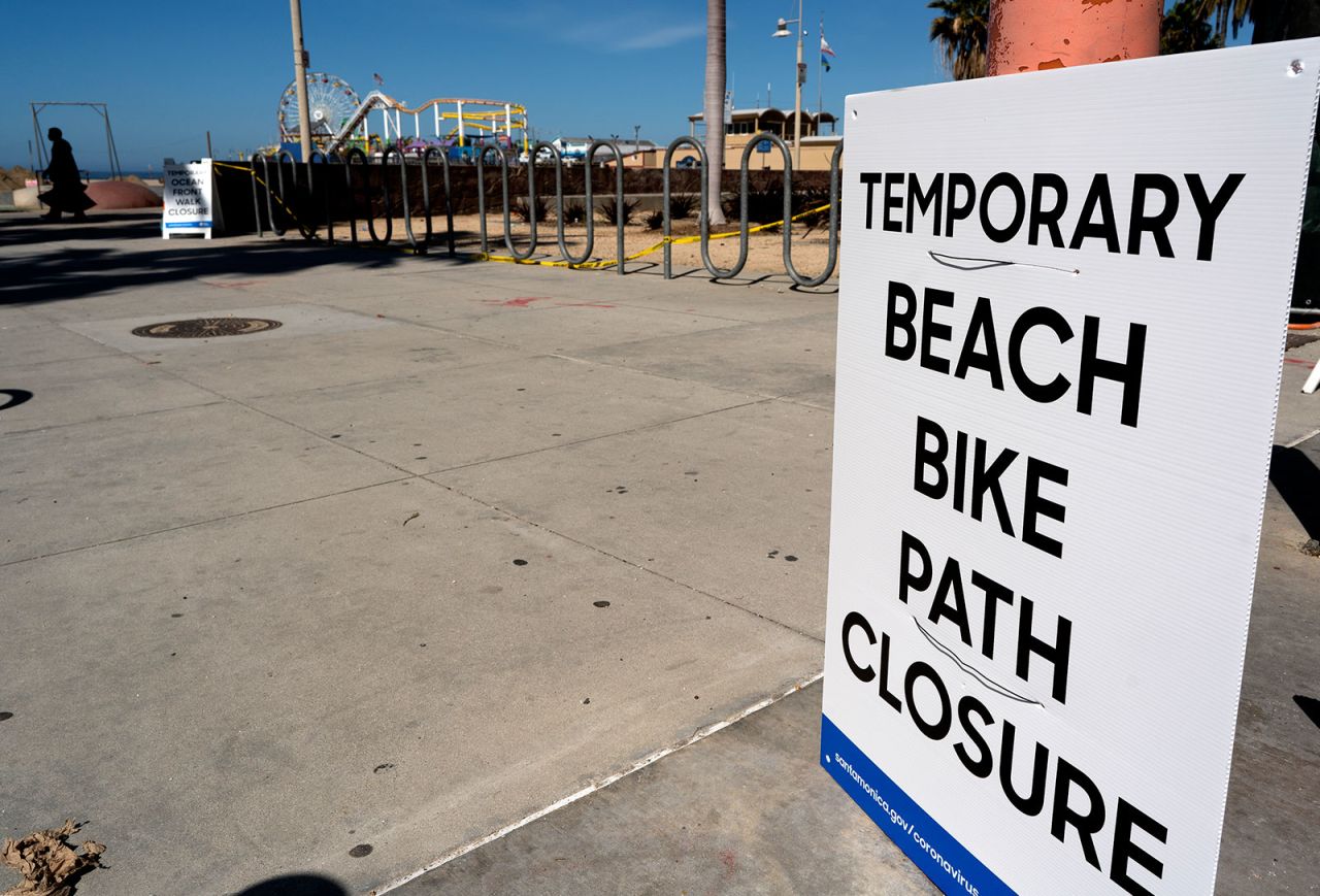 In an attempt to keep people social distancing due to COVID-19, a temporary closed sign is posted at the beach near the Santa Monica Pier in Santa Monica, California on April 23.