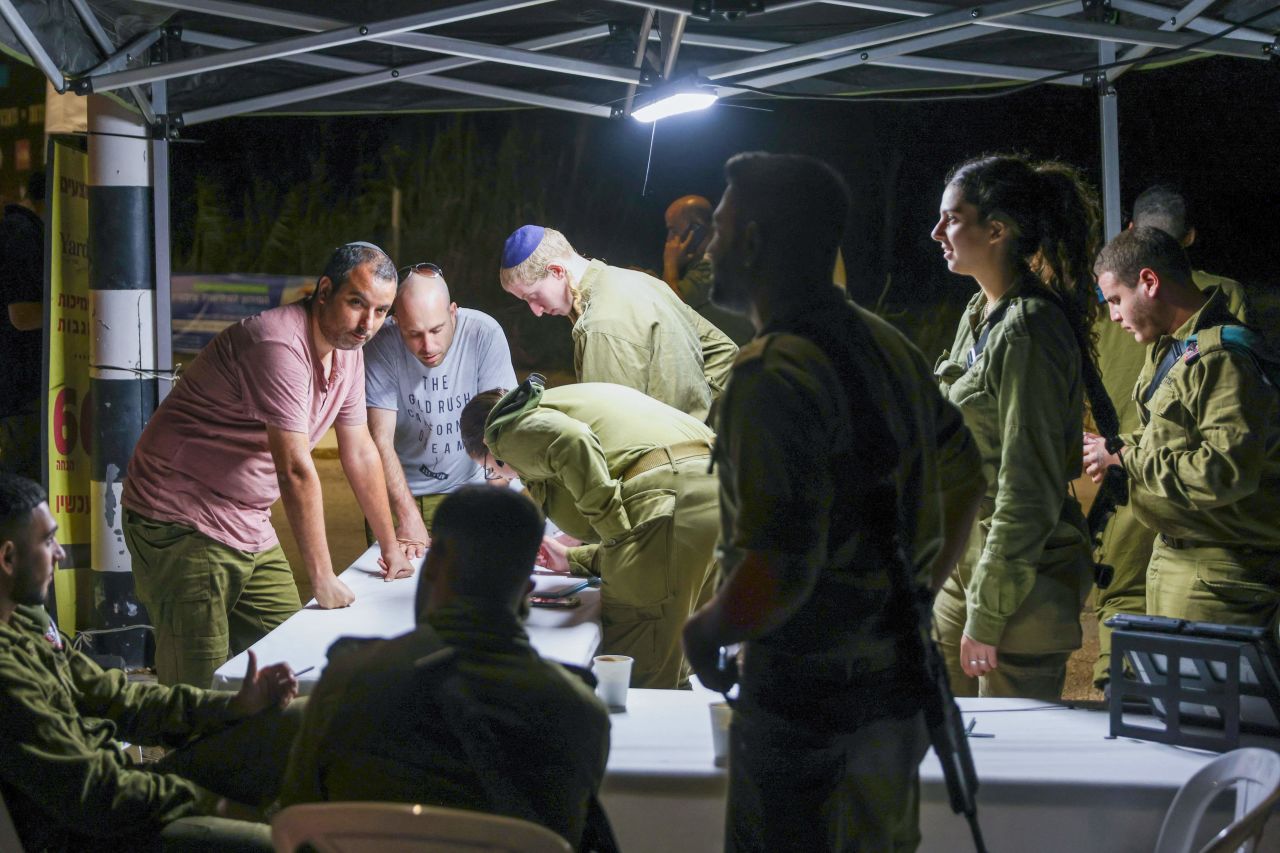 Reserve Israeli soldiers line up to register for duty in a northern Israeli town on October 7, 2023.