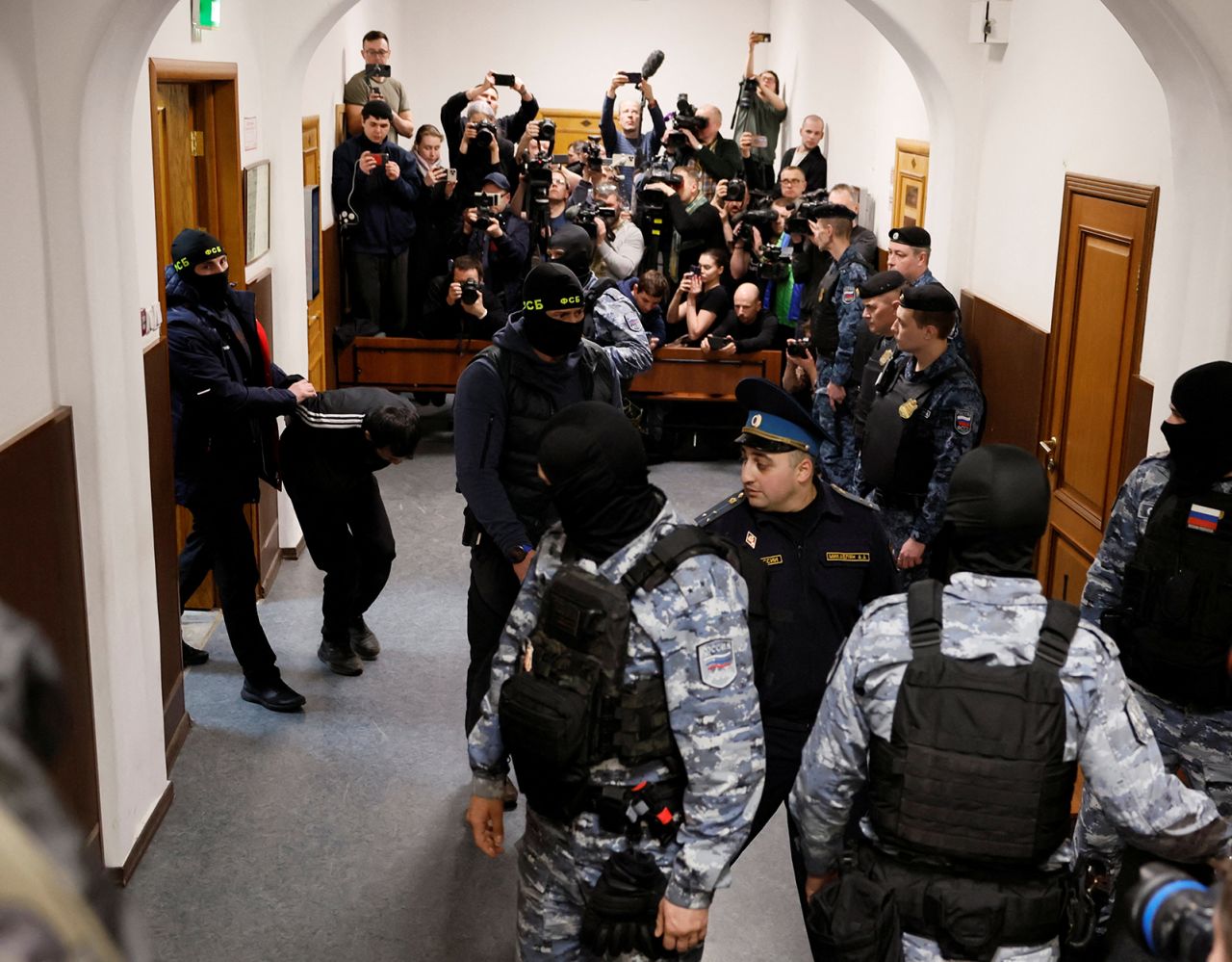 A suspect is escorted before a court hearing at the Basmanny district court in Moscow, Russia March 24.