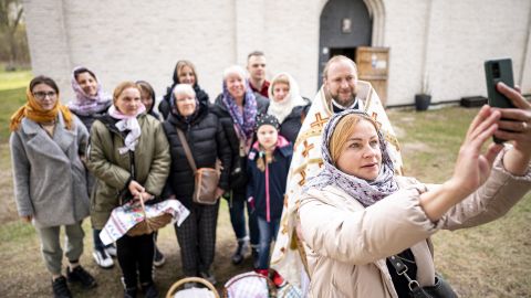 A woman takes a selfie with a group of Ukrainian refugees in front of the St. George Russian Orthodox Monastery in Milmersdorf, Germany on Sunday April 24.