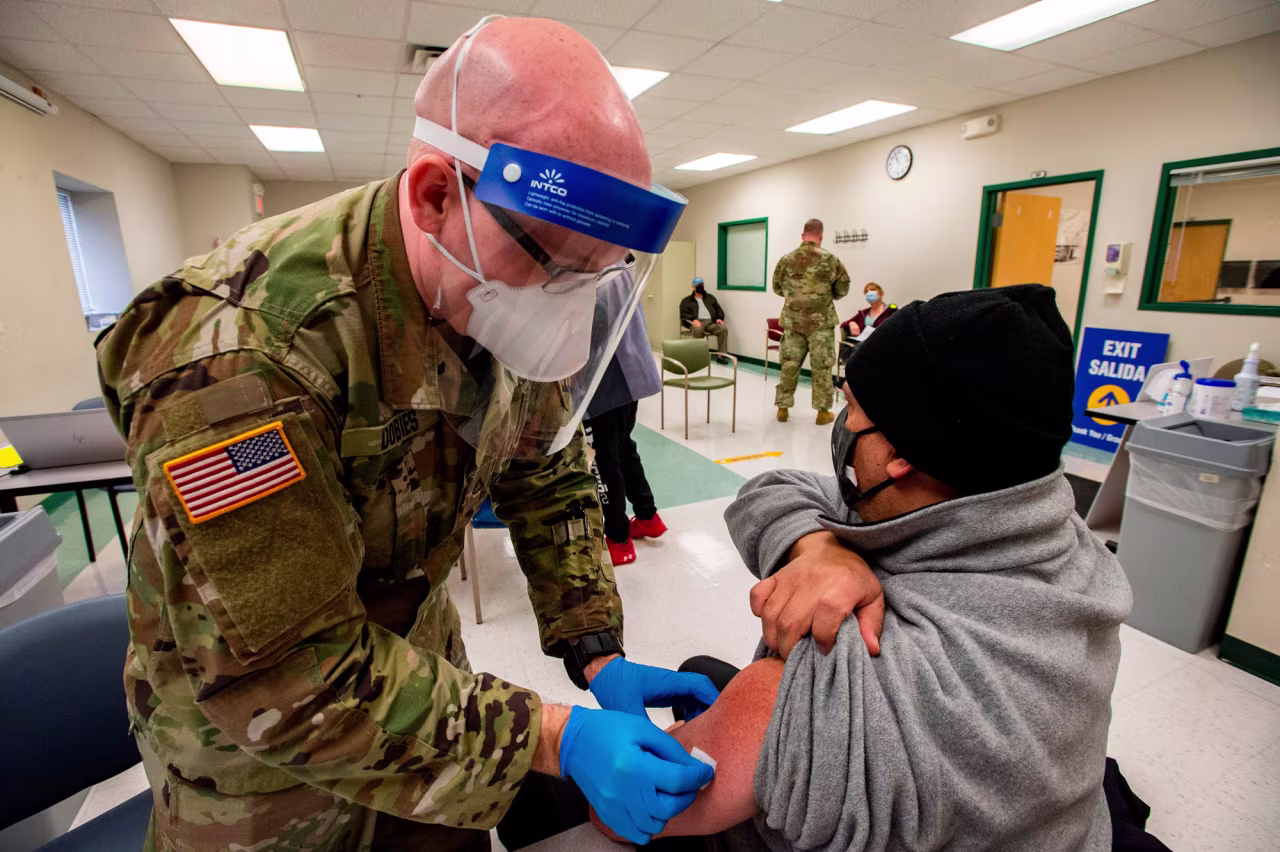 A soldier prepares to vaccinate a man at an East Boston Neighborhood Health Center Vaccination Clinic in Boston on February 16.