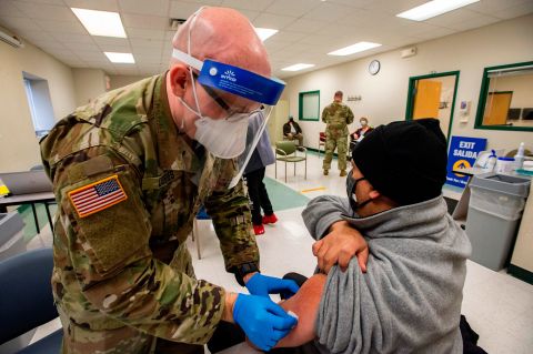 A soldier prepares to vaccinate a man at an East Boston Neighborhood Health Center Vaccination Clinic in Boston on February 16.