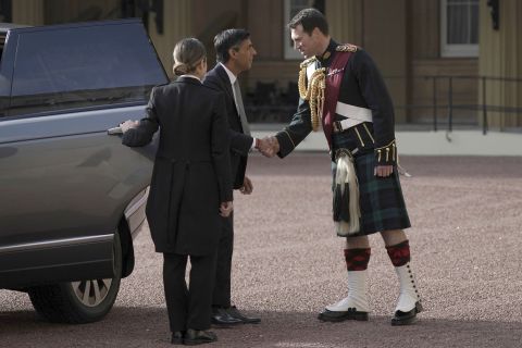 Rishi Sunak is greeted by King Charles III's equerry, Lieutenant Colonel Johnny Thompson, as he arrives at Buckingham Palace for an audience with King Charles III in London, Tuesday.