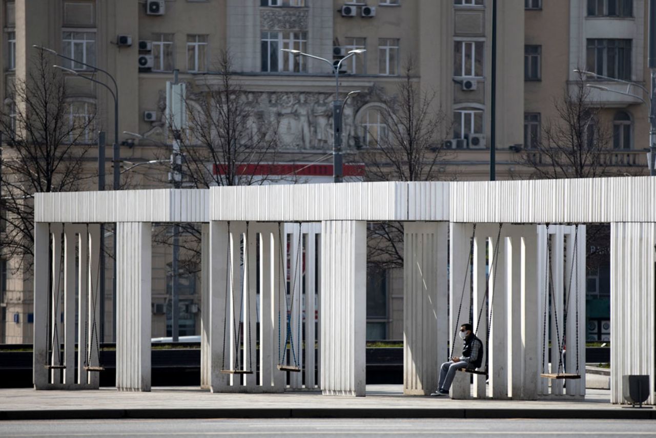 A man, wearing face mask to protect from coronavirus, rests on swing during a self-isolation regime due to coronavirus, in a Square in Moscow, Russia, Monday, April 13.