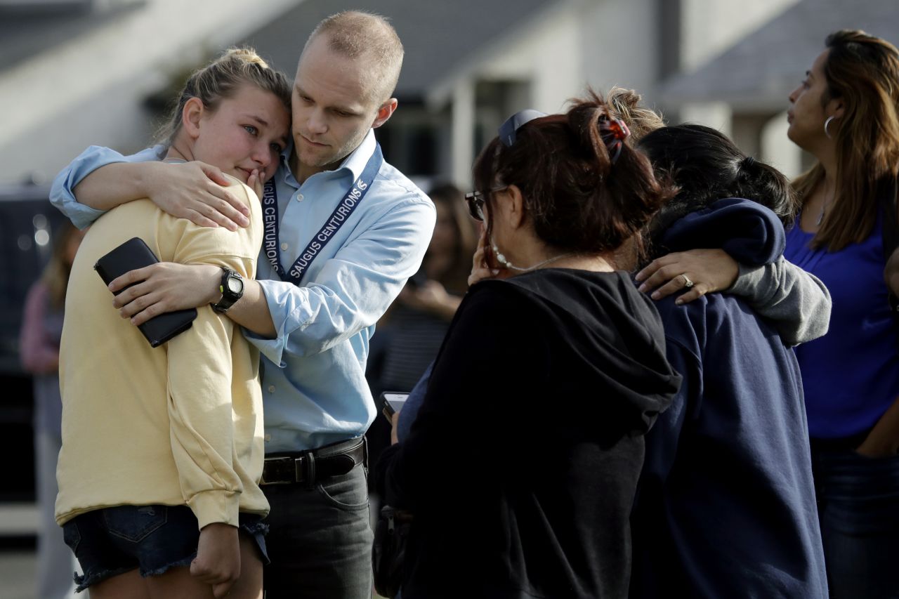 D.J. Hamburger, center in blue, a teacher at Saugus High School, comforts a student after reports of a shooting at the school on Nov. 14 in Santa Clarita, California.