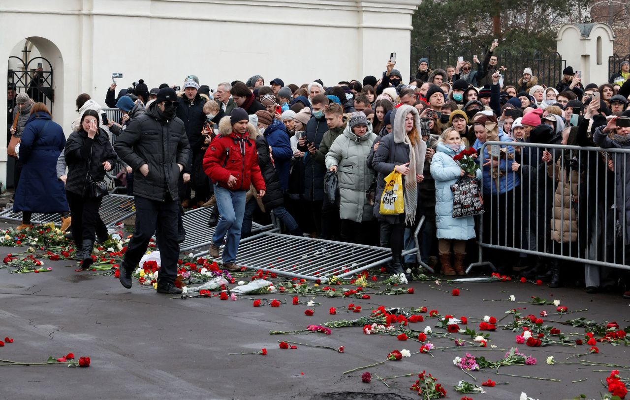 People knock down barriers while leaving an area outside the Church of the Icon of the Mother of God 'Quench My Sorrows' after the funeral service on Friday.
