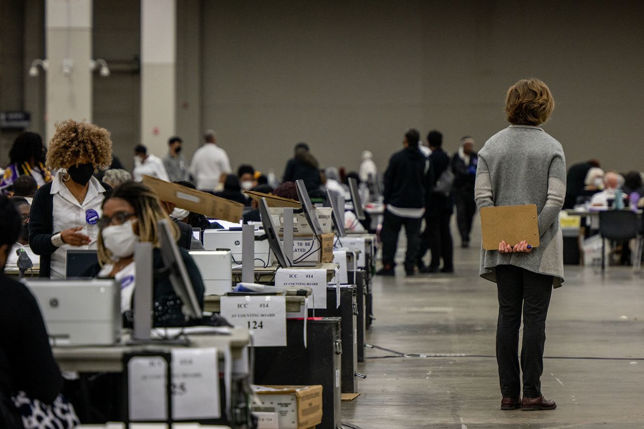 A poll challenger oversees election inspectors at the Huntington Place convention center in Detroit on Tuesday. 