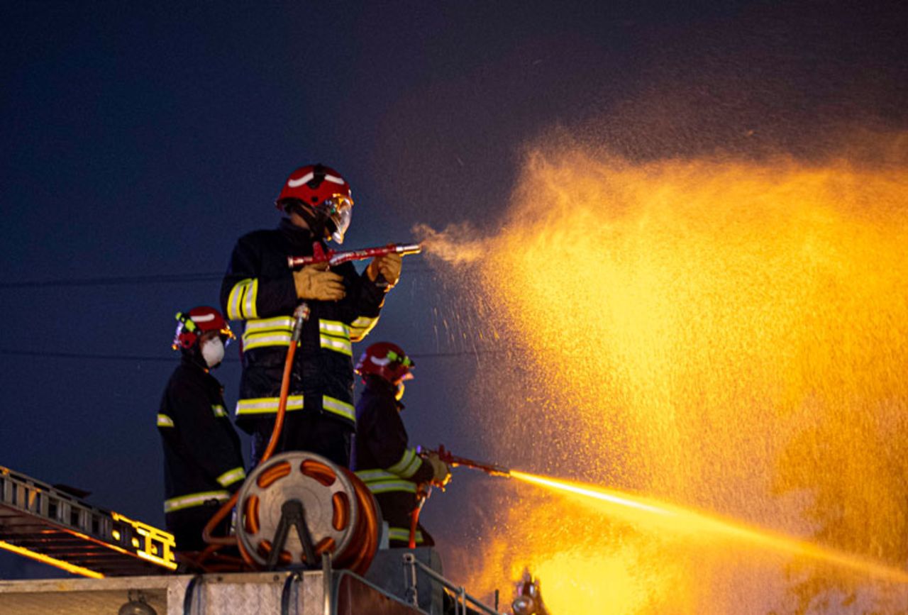 Indian firefighters spray disinfectants as a preventive measure against the spread of the new coronavirus on a street in Gauhati, India, on Wednesday, March 25. 