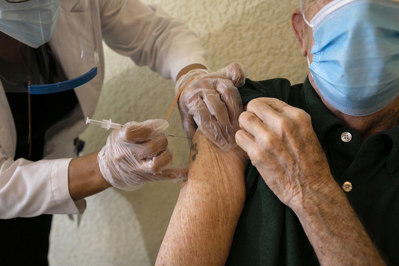 A resident receives a Pfizer-BioNtech Covid-19 vaccine from a healthcare worker at The Palace, an independent living community for seniors, at Coral Gables in Miami, on January 12.