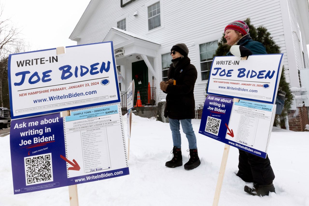 Supporters of President Joe Biden's write-in campaign stand outside a polling site in Holderness, New Hampshire. Biden isn't appearing on the ballots because of an internal party dispute over the primary's date. 