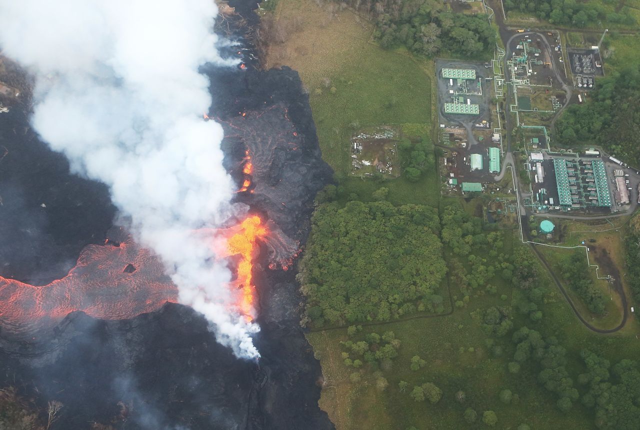 Lava erupts and flows from a Kilauea volcano fissure, near to the Puna Geothermal Venture (PGV) plant (TOP R), on Hawaii's Big Island.