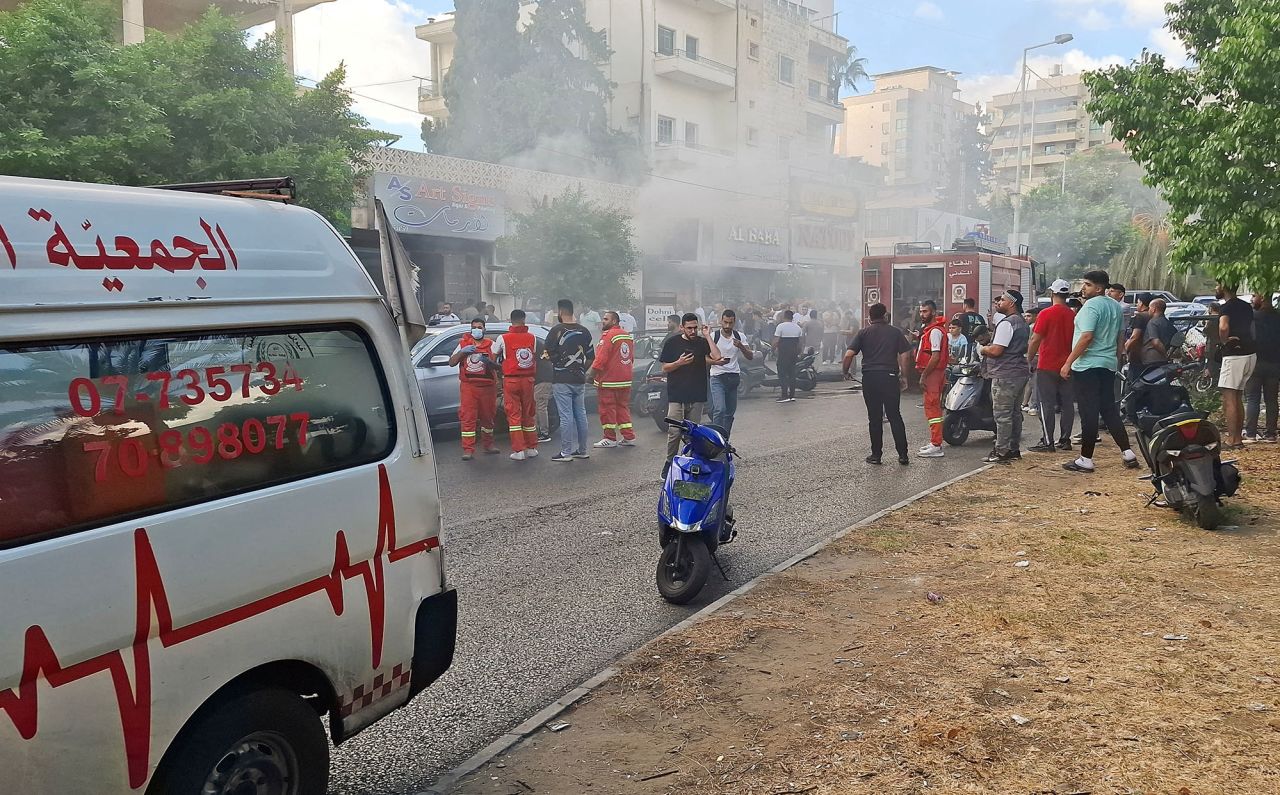 Smoke rises from a mobile shop as civil defence members gather in Sidon, Lebanon, on September 18.